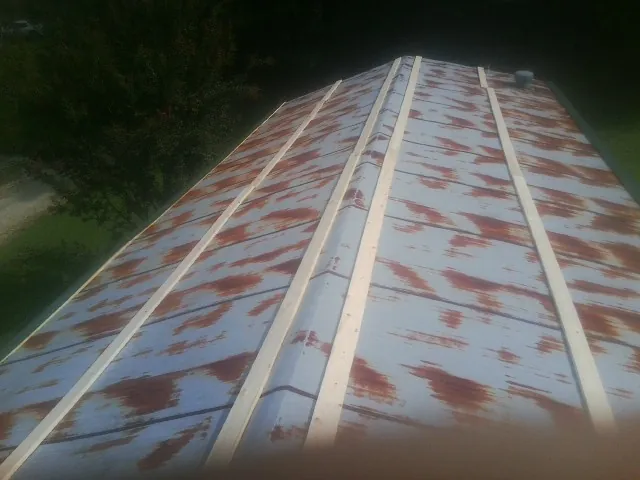 Rusted metal roof panels with new wood purlins before replacement — Storm Damage Roof Repair in Warsaw by Roofing Brothers