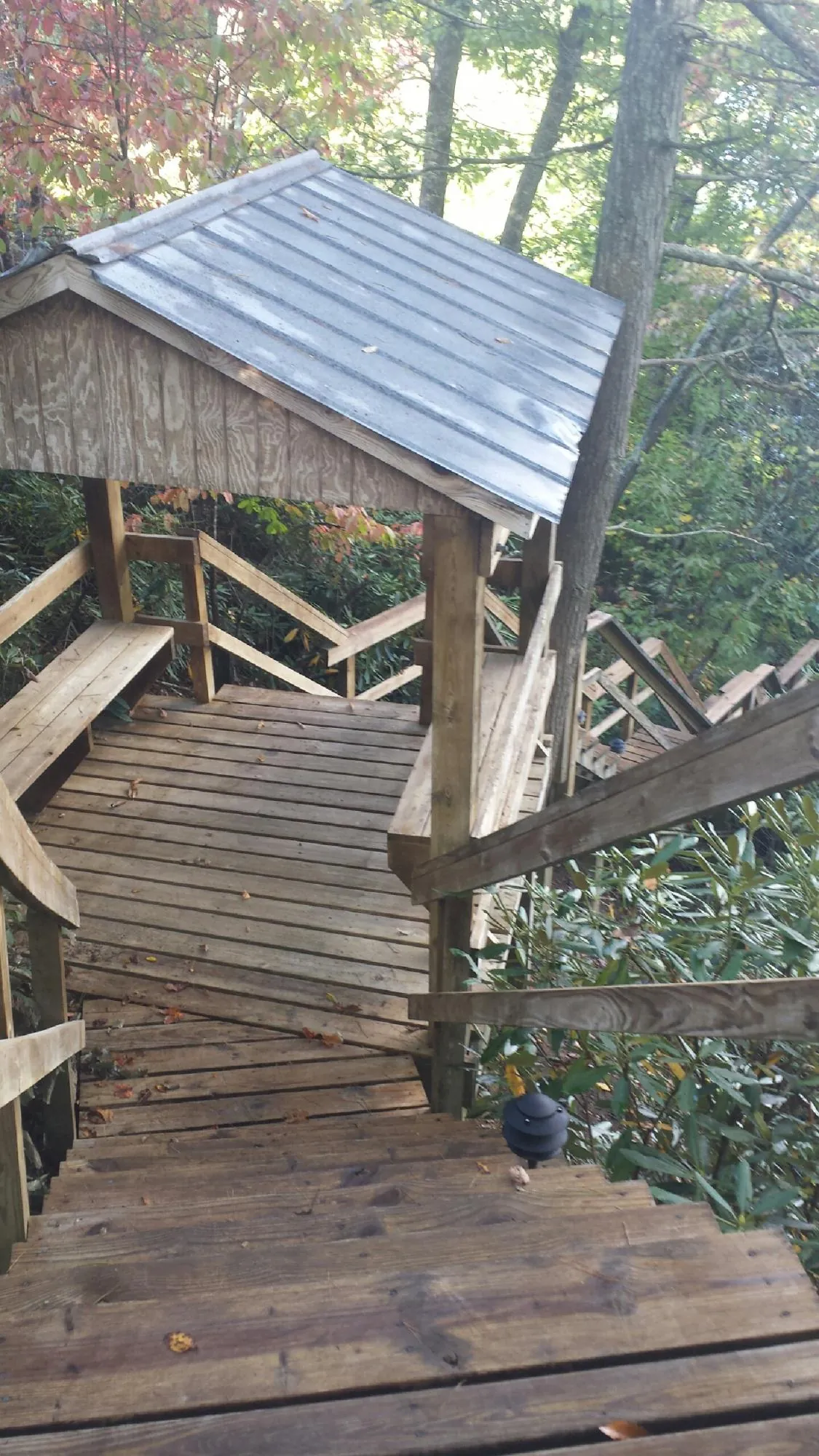 Metal roofed shelter over wooden steps on a wooded walkway — Skylight Repair & Installation work by our crew in Warsaw